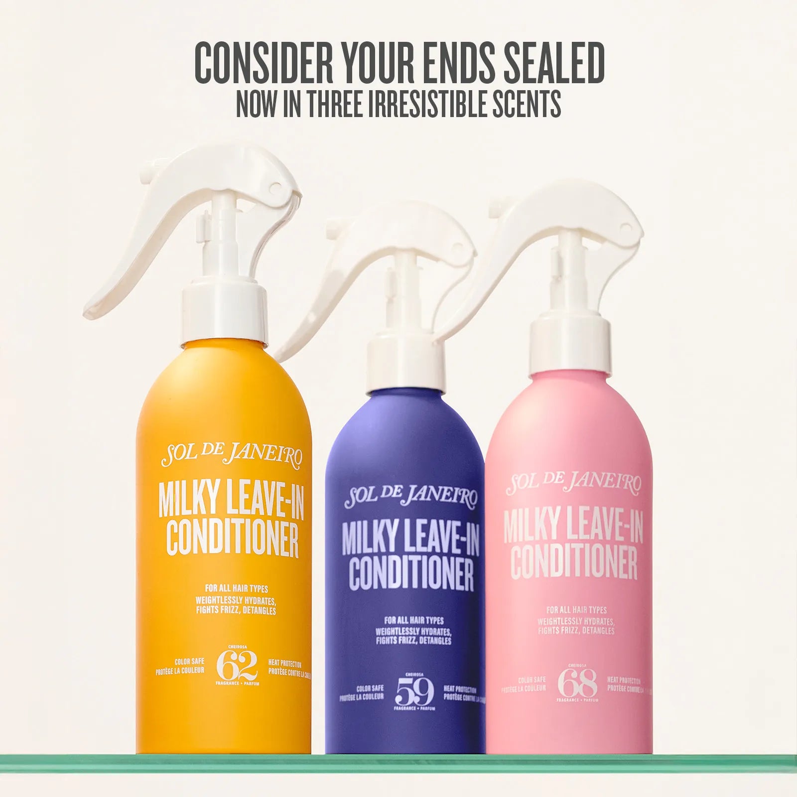 Three bottles of Sol de Janeiro Milky Leave-In Conditioner in yellow, blue, and pink on a white background.